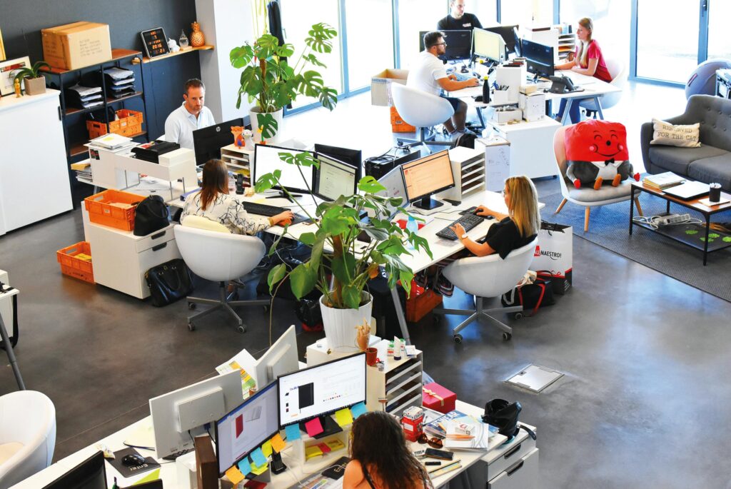 O design biofílico aumenta a produtividade porque cria ambientes de trabalho mais saudáveis, confortáveis e equilibrados. A conexão com elementos naturais ajuda o cérebro a funcionar melhor, reduzindo o estresse e melhorando a concentração ao longo do dia. Em escritórios modernos, a biofilia deixou de ser apenas uma tendência estética e passou a ser uma estratégia para melhorar desempenho e bem-estar.
Um dos principais fatores que tornam o design biofílico tão eficiente é a presença da natureza no ambiente corporativo. Plantas naturais, iluminação natural, ventilação adequada e materiais orgânicos ajudam a criar espaços mais agradáveis e menos cansativos. Isso reduz a fadiga mental e aumenta a capacidade de foco dos colaboradores.
A luz natural, por exemplo, possui um impacto direto na produtividade. Ambientes iluminados naturalmente ajudam a regular o relógio biológico, melhoram o humor e aumentam os níveis de energia. Funcionários que trabalham próximos a janelas ou em espaços com maior entrada de luz natural costumam apresentar melhor desempenho e mais disposição durante o expediente.
Outro benefício importante do design biofílico no escritório é a redução do estresse. Ambientes fechados, artificiais e sem conexão com a natureza podem gerar tensão, ansiedade e sensação de esgotamento. Já espaços biofílicos transmitem conforto psicológico e promovem sensação de calma, contribuindo para a saúde mental no trabalho.
Além disso, o design biofílico também estimula a criatividade e a colaboração entre equipes. Ambientes naturais favorecem pensamentos mais criativos e ajudam a melhorar a comunicação entre profissionais. Isso é especialmente importante em empresas inovadoras que dependem de ideias, produtividade e integração entre setores.
O uso de madeira, jardins verticais, cores naturais e áreas de descanso com plantas também ajuda a tornar o ambiente mais acolhedor e motivador. Pequenas mudanças já podem gerar grandes resultados no clima organizacional e na satisfação dos funcionários.
Por isso, investir em design biofílico no trabalho significa investir em produtividade, bem-estar e qualidade de vida. Empresas que aproximam natureza e trabalho criam ambientes mais humanos, eficientes e preparados para o futuro.