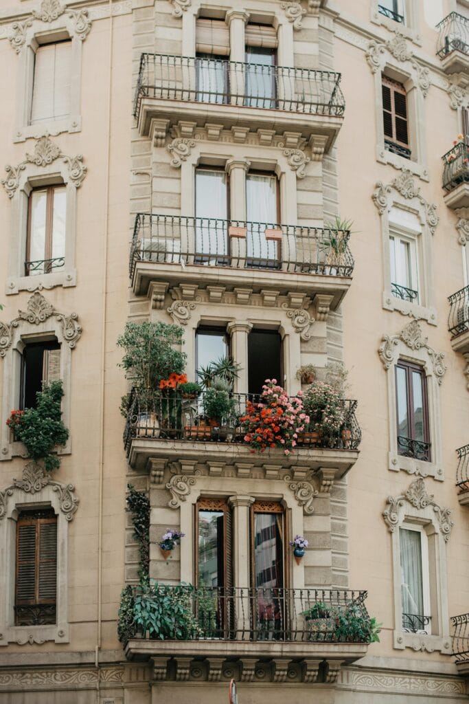 Sacada biofílica em apartamento pequeno com flores vermelhas