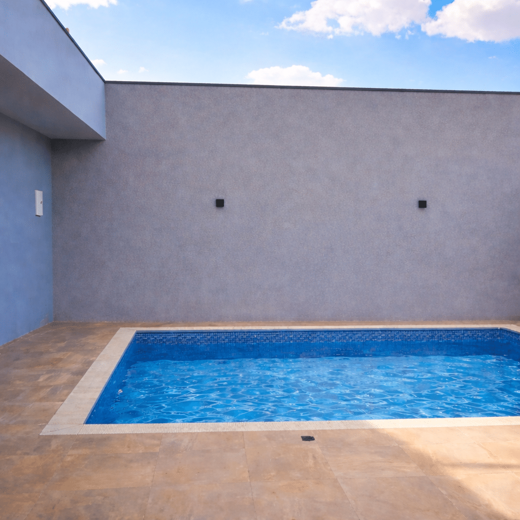 Piscina e área antes da consultoria de paisagismo, parede nua e sem vegetação