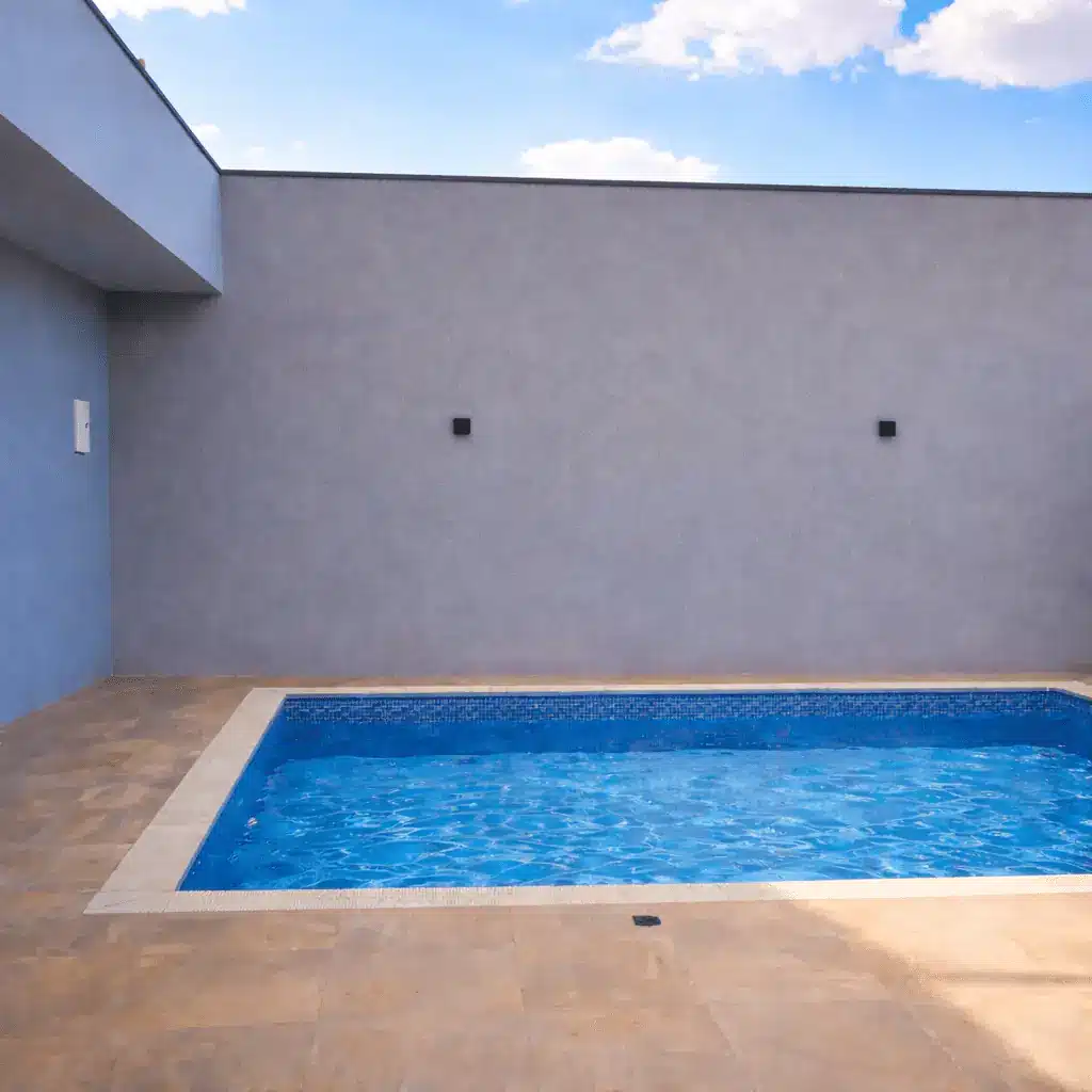 Área de piscina antes do paisagismo, com parede nua e sem vegetação